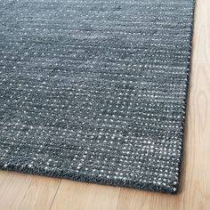 a grey rug on the floor with wooden floors