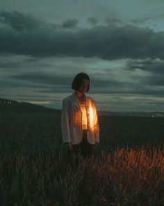 a woman standing in the middle of a field