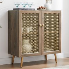 a cabinet with some glass bowls on top of it next to a vase and other items