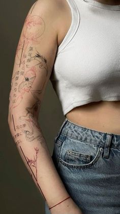 a woman with a tattoo on her arm is standing and looking at the camera while wearing jeans