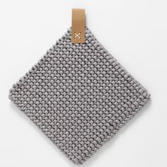 a gray and white square shaped object with a tag on the side that says it's made out of fabric