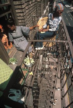 two people sitting on top of a building with lots of metal bars and ladders