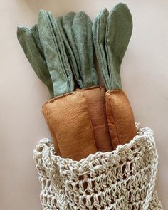 two oven mitts in a crocheted bag on a white tablecloth background