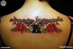 the back of a woman's shoulder with roses on it and an arrow in the middle