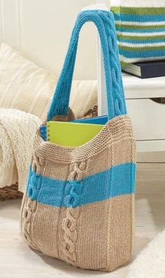 a knitted bag sitting on top of a wooden floor next to a white chair