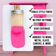 a pink paint brush sitting on top of a wooden table next to a white wall