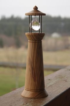 a wooden post with a light on it sitting next to a window overlooking a field