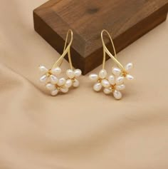 These floral pearl drop earrings are handmade with multiple real AAA quality freshwater pearls and are simply beautiful. The pearls have a smooth, natural white surface that is glowing, and the pearls are designed with a flower-like pattern that encases the pearl and adds a charming touch of beauty. The earrings are delicate, and the white pearls and floral design perfectly complement each other to form an exquisite piece of jewelry. The perfect statement piece for a bride or make them your go-t Wedding Pearl Earrings Dangle, Bride Earrings Pearl, Pearl Ball Earrings, Unique Pearl Earrings, Flower Pearl Earrings, Pearl Earrings Handmade, Earrings Multiple, Real Pearl Earrings, Long Pearl Earrings