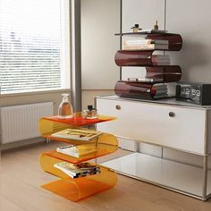 a living room with an orange table and some books on the shelf next to it