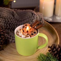 a cup filled with hot chocolate chips and cinnamons on top of a wooden plate