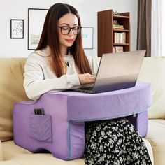 a woman sitting on a couch using a laptop computer