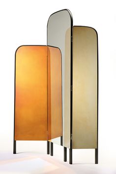 two tall mirrors sitting next to each other on top of a white floor covered in light