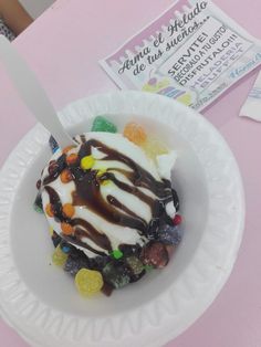 a white bowl filled with ice cream covered in candy