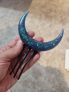 "In Spain, a peineta is a large decorative comb usually worn under a mantilla, or lace head covering. This piece looks great over a ponytail or bun. Crescent Moon is cast in blue resin with iridescent glitter. Approximate size 4\" x 6\". A beautiful addition to your hair garden." Weird Accessories, Moon Hair Stick, Moon Hair, Moon Crescent, Insect Jewelry, Hair Stick, Hair Sticks, Head Covering, Hair Comb