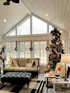 a living room filled with furniture and a christmas tree in the middle of the room