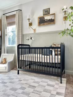 a baby's room with a crib, rocking chair and pictures on the wall