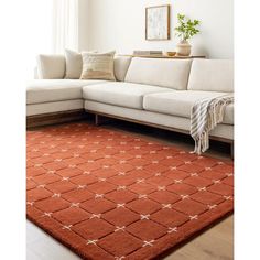 a living room with a white couch and orange rug