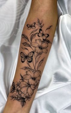 a woman's arm with flowers and butterflies on it