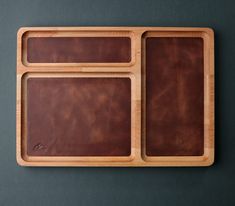 two wooden trays with leather handles on a gray surface, one is empty and the other has three compartments