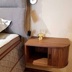 a small wooden side table next to a bed