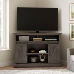 a flat screen tv sitting on top of a wooden entertainment center