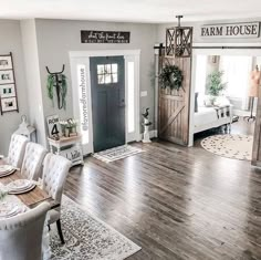 a large open concept living room with wood flooring and white furniture, decorated for christmas