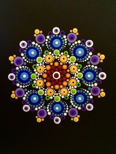 an image of a colorful flower made out of beads on a black background with circles and dots in the center