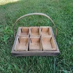 a wooden box with six compartments sitting in the grass