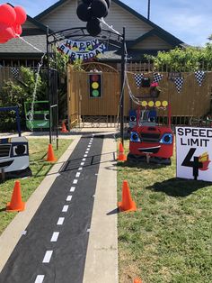 a birthday party with cars and balloons on the side of the road that says happy birthday speed limit