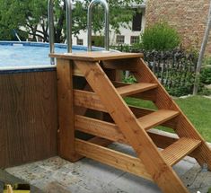 an above ground swimming pool with steps leading up to the top and below it is a wooden ladder