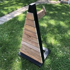 a wooden bench sitting on top of a lush green field next to a park path