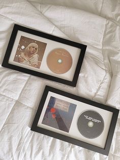 two framed cds are sitting on a bed