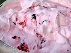 an image of some food that is covered in pink and white icing with black spots