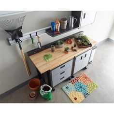 a kitchen counter with pots and plants on it next to a racquet rack