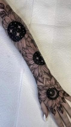 a woman's arm with sunflowers and stars on it