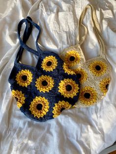 two crocheted sunflower purses sitting on top of a white bed next to each other