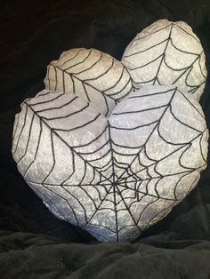 two white rocks with spider web designs on them