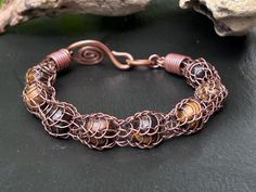 This beautiful bracelet is entirely handmade designed and created by me.  The metal is solid copper and it was salvaged from an old electrical extension cord. The chain is woven from a single piece of 24 gauge copper wire using the Viking knit technique. The beads are made of natural tigers eye gemstone and they are perfectly captured and secured onto the chain.  Comfortable and versatile it is also very light and flexible, the hook clasp makes it easy to put on and off.  Please make sure to mea Viking Knit Jewelry, Tigers Eye Bracelet, Woven Jewelry, Knit Jewelry, Viking Knit, Tiger Eye Bracelet, Tigers Eye Gemstone, Eye Bracelet, Copper Chain