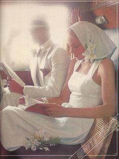 a man and woman sitting next to each other in front of a window holding books