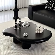 a black coffee table with white balls on it in a living room next to a couch