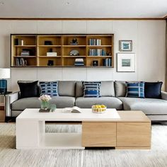 a living room filled with furniture next to a window covered in bookshelves and windows