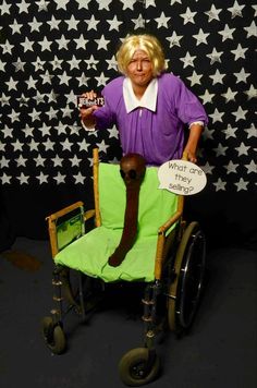 a woman sitting on top of a green chair holding a sign that says what care is necessary