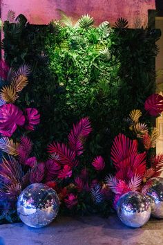 the wall is covered with plants and mirrored balls