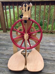 a wooden spinning machine on a deck with trees in the background