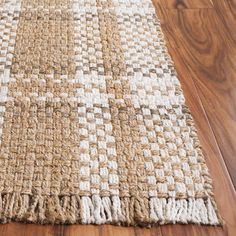 a brown and white rug on top of a wooden floor