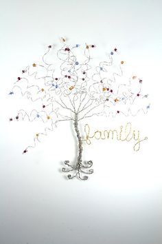 a wire tree with the word family written in gold and silver on it's branches