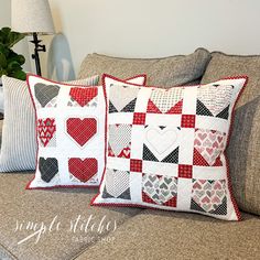 two pillows are sitting on a couch with hearts in the center and one is made out of patchwork fabric