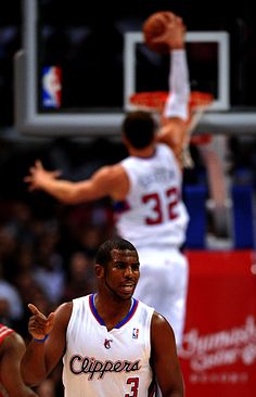 a basketball player is about to dunk the ball in front of an opposing player