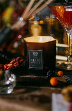 a candle sitting on top of a table next to some fruit and wine glasses