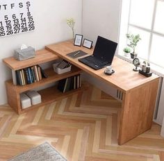 a laptop computer sitting on top of a wooden desk next to a bookshelf